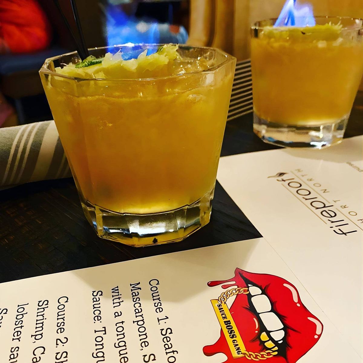 Two mango cocktails made with Liquid Gold hot sauce on a restaurant tasting menu card