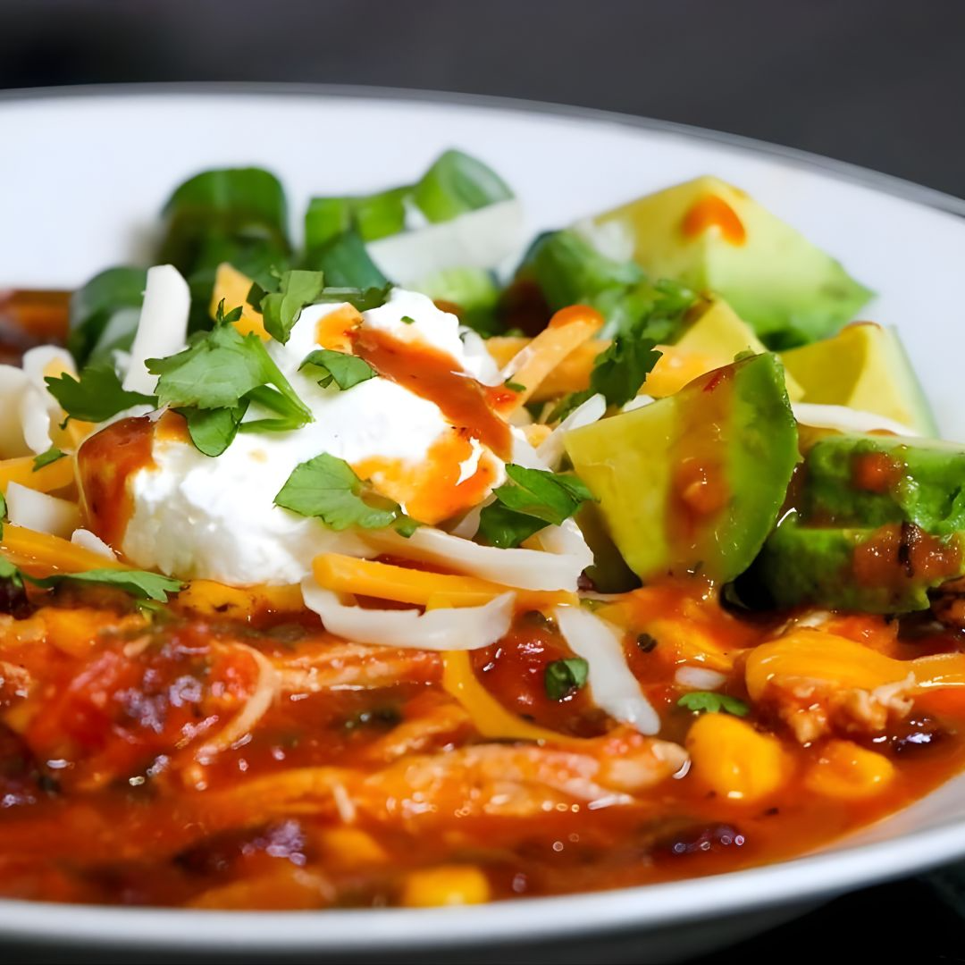 Chicken tortilla soup topped with avocado, crema and La Jefa garlic scorpion hot sauce